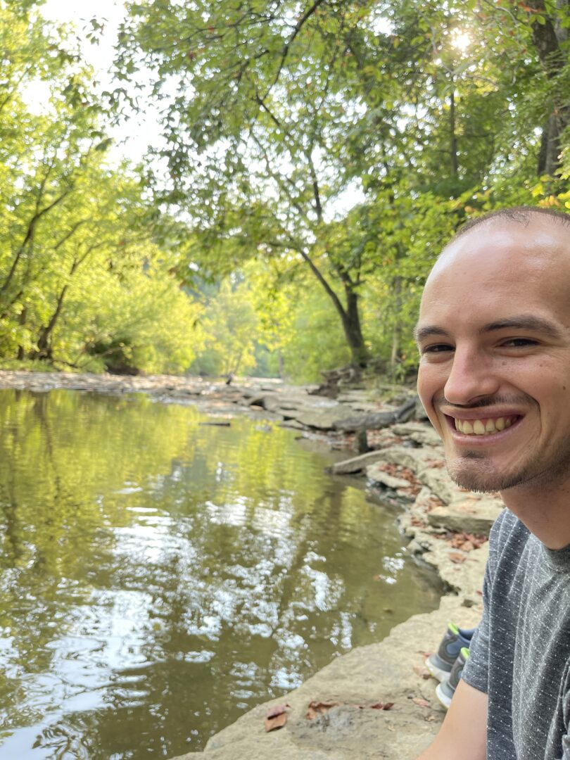Me sitting beside a quite stream in springtime
